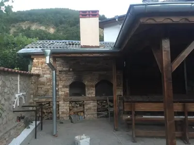 a brick oven with a chimney on a house at Elenite Guesthouse in Gotse Delchev