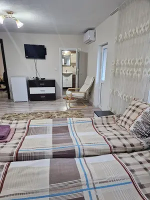 a bedroom with a bed and a tv in it at Elenite Guesthouse in Gotse Delchev