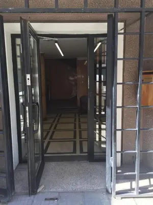 an open door of an empty building with glass at Rooftop Oscar Rooms in Sofia
