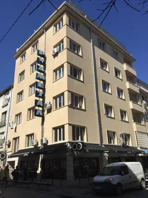 a building with a car parked in front of it at Rooftop Oscar Rooms in Sofia