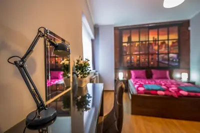 a room with a bed with pink pillows and a lamp at 5th Avenue Sofia Two Bedroom, Two Bathroom, Positano Street Suite by Flat Mаnager in Sofia