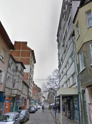 a person walking down a city street with buildings at 5th Avenue Sofia Two Bedroom, Two Bathroom, Positano Street Suite by Flat Mаnager in Sofia