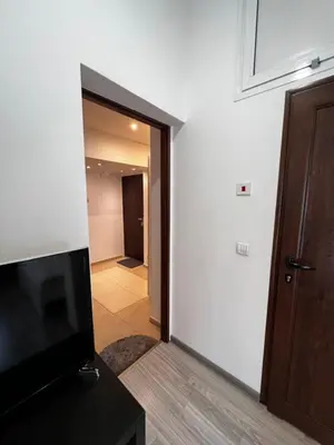 a living room with a television and a hallway at The Yellow House in Sofia in Sofia