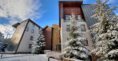 a building with snow covered trees in front of it at Euphoria Club Hotel in Borovets