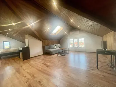 an attic room with a piano and a table at Къща за гости Алида in Sapareva Banya
