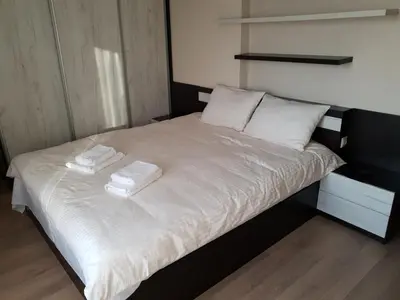 a bed with white sheets and two towels on it at Luxury Two Bedroom Flat in Blagoevgrad