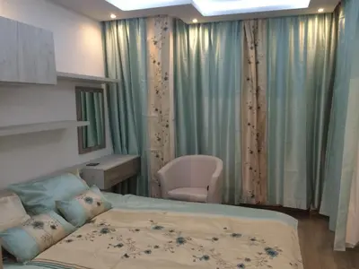 a bedroom with a bed and a chair in it at Luxury Two Bedroom Flat in Blagoevgrad