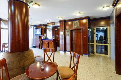 a living room with a table and a wood stove at Nadejda Hotel in Sofia