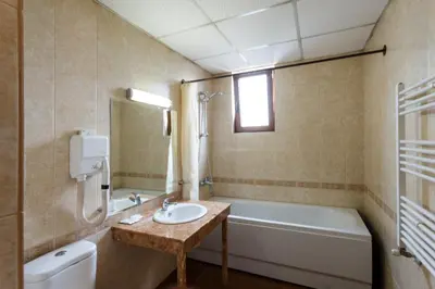 a bathroom with a sink and a bath tub at Nadejda Hotel in Sofia