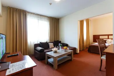 a hotel room with a couch and a table at Nadejda Hotel in Sofia