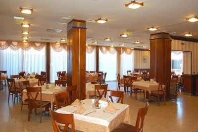 a dining room with tables and chairs in a restaurant at Nadejda Hotel in Sofia