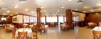 a restaurant with tables and chairs in a room at Nadejda Hotel in Sofia