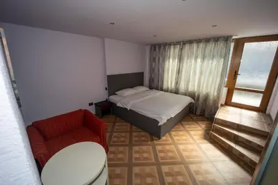 a small bedroom with a bed and a chair at Banya Guest Rooms 23 in Banya