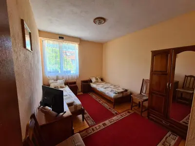 a living room with two beds and a window at Villa Mura in Razlog