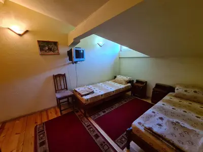 an attic room with two beds and a tv at Villa Mura in Razlog