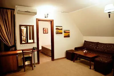 a living room with a couch and a table and a mirror at Favorit Hotel in Sofia