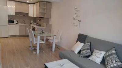 a living room with a couch and a table and a kitchen at Modern apartment Sofia center in Sofia