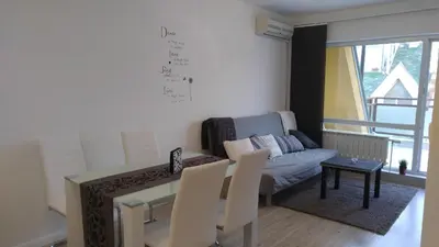 a living room with a couch and a table and chairs at Modern apartment Sofia center in Sofia