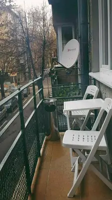 a balcony with two chairs and a trash can at Central Apartment in Sofia