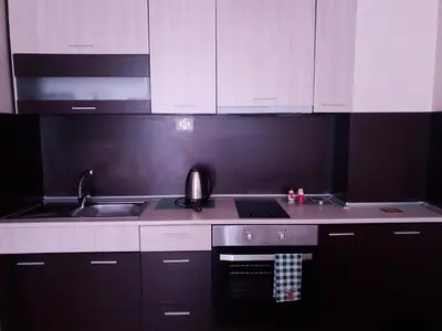 a kitchen with white cabinets and a stove and a sink at Cosy Apartment - City Centre in Blagoevgrad