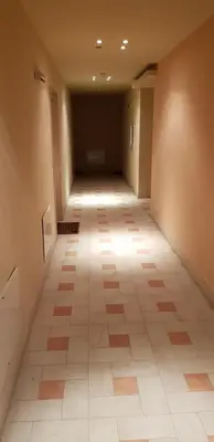 an empty hallway with a tile floor in a building at EFO Apartment in Bansko