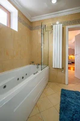 a bathroom with a tub and a glass shower at RENOVATED Boutique Apartments Petrus in Sofia