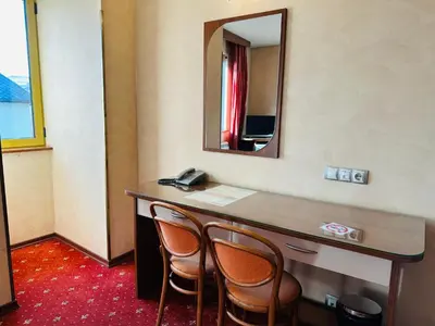 a hotel room with a desk with chairs and a mirror at Hotel Rai in Sofia