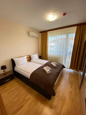 a bedroom with a large bed with two towels on it at Pravets Resort Apartments in Pravets