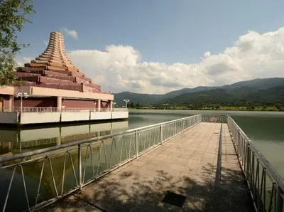a building on the side of a lake with a bridge at Pravets Resort Apartments in Pravets