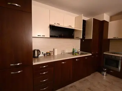 a kitchen with wooden cabinets and a counter top at Pravets Resort Apartments in Pravets