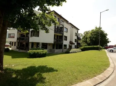 a large building with a green lawn in front of it at Pravets Resort Apartments in Pravets