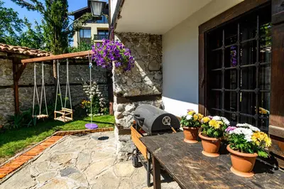 a wooden table with potted flowers on a patio at Banskovilla Zlateva House in Bansko