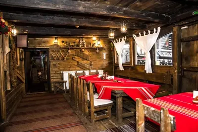 a dining room with a red table and chairs at Banskovilla Zlateva House in Bansko