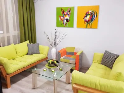 a living room with yellow couches and a table at Best Guest Apartments in Plovdiv