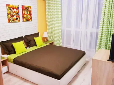 a bedroom with a bed with yellow pillows at Best Guest Apartments in Plovdiv