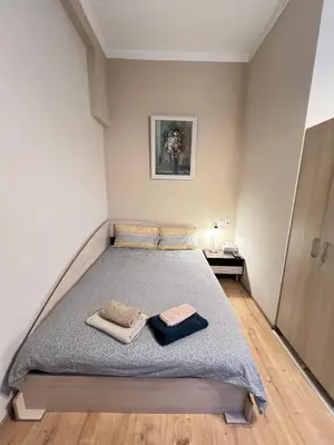 a bedroom with a bed with two towels on it at Budapest Central Cozy Studio w Working Space and WiFi in Sofia