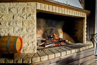 a brick fireplace with a fire in it at Apartment Biliana in Pamporovo