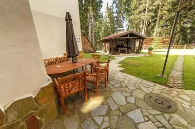 a patio with a table and chairs and an umbrella at Apartment Biliana in Pamporovo