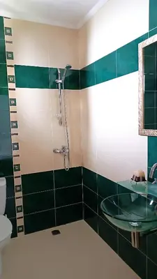 a bathroom with a glass shower and a sink at Guesthouse White Margarit in Melnik
