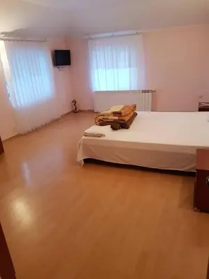 a bedroom with a large bed and a wooden floor at Guest House Iveta in Sofia