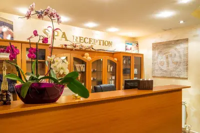 a reception desk with a vase of flowers on it at SPA Hotel Olymp in Velingrad