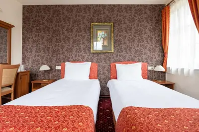 a hotel room with two beds and a window at Hotel Hadjiite in Koprivshtitsa