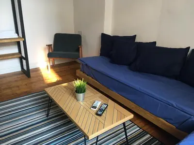 a living room with a blue couch and a table at Generaator Sofia in Sofia