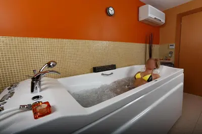 a little girl sitting in a bath tub at Evridika Hotel in Devin