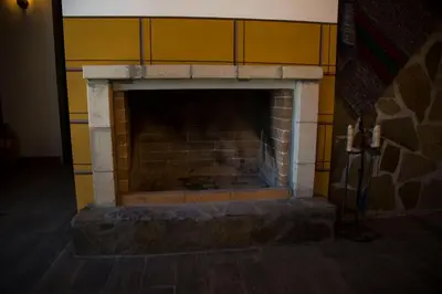 a brick fireplace in a room with a yellow wall at Red House in Koprivshtitsa