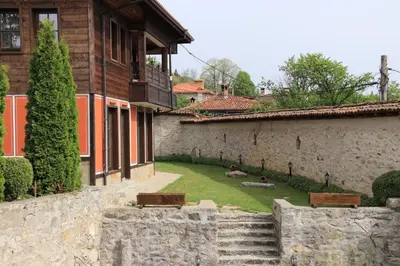 a courtyard of a building with benches in a yard at Red House in Koprivshtitsa