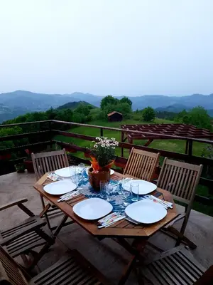 a wooden table with plates and wine glasses on it at Karadzhovata Kashta in Zlatograd