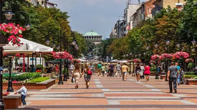 a group of people walking down a city street at Sunny Central Apartment in Sofia