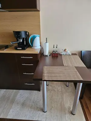 a kitchen with a wooden table with a coffee maker at City Sandanski in Sandanski
