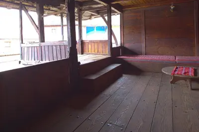 an inside of a wooden cabin with benches and a tub at ЧОЛАКОВАТА КЪЩА in Koprivshtitsa